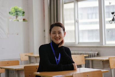 Portrait of young woman sitting at table