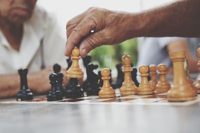 Midsection of man playing chess with friend