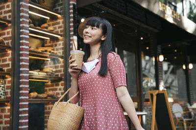 Young woman looking down while standing at store