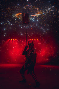 Rear view of man standing on street at night