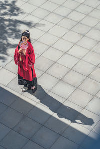 Full length of woman standing on footpath