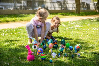 Portrait of smiling family playing with balloons on field