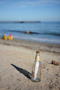 Close-up of water bottle on beach