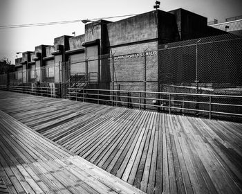 Metallic railing by building against sky