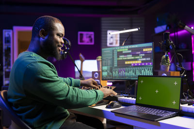 Side view of man using laptop at home