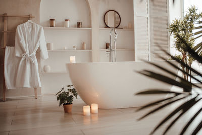 Luxury interior of big bathroom at modern african style with oval bathtub in natural lighting