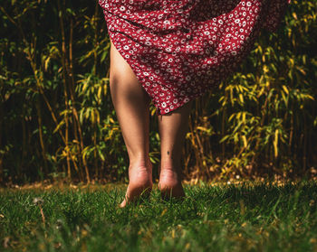 Low section of woman standing on field