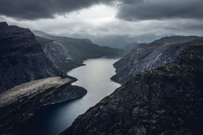 Aerial view of lake by mountain against sky