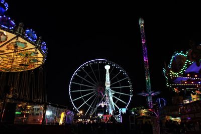 Low angle view of illuminated ferris wheel against sky at night