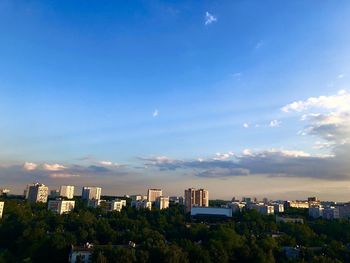 Buildings in city against blue sky