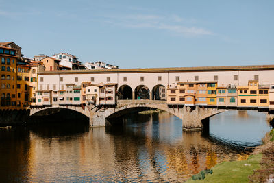 Arch bridge over river against sky