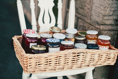 Close-up of preserves in wicker basket on chair