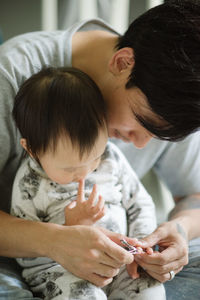 Close-up of father clipping baby's fingernails