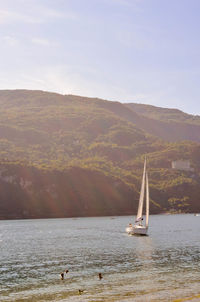 Sailboat sailing on sea against sky