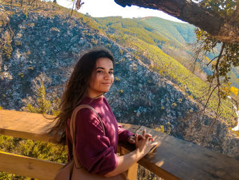 Portrait of smiling woman against trees