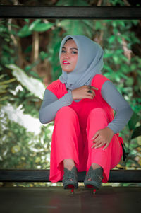 Portrait of young woman sitting on bench