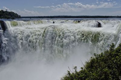 Scenic view of waterfall against sky