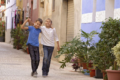 Two happy kids outdoors in the street european city on summer day