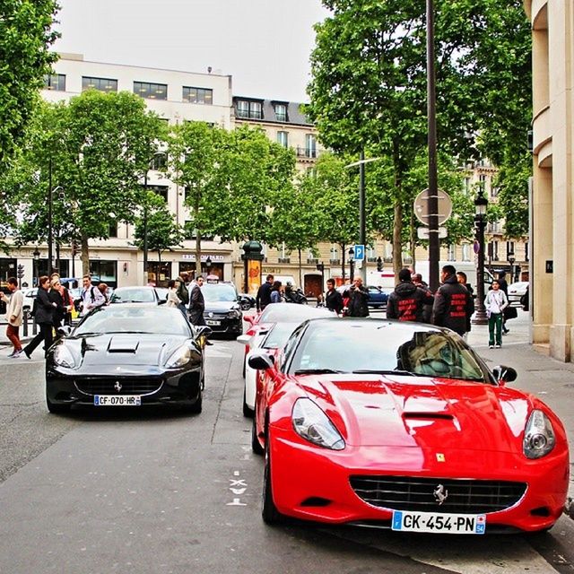 building exterior, land vehicle, car, transportation, street, mode of transport, architecture, city, built structure, men, tree, city life, person, lifestyles, road, incidental people, city street, leisure activity, walking