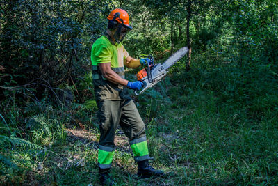 Forest worker working in the forest with chainsaw