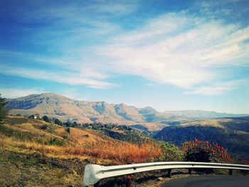 Road by mountains against sky