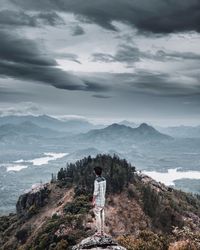 Man standing on mountain against sky