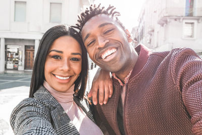 Portrait of smiling friends enjoying in city