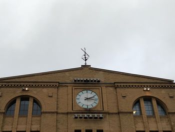 Low angle view of weather vane against sky