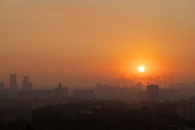 Buildings in city against sky during sunset