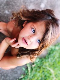 High angle view of cute girl looking away while crouching outdoors