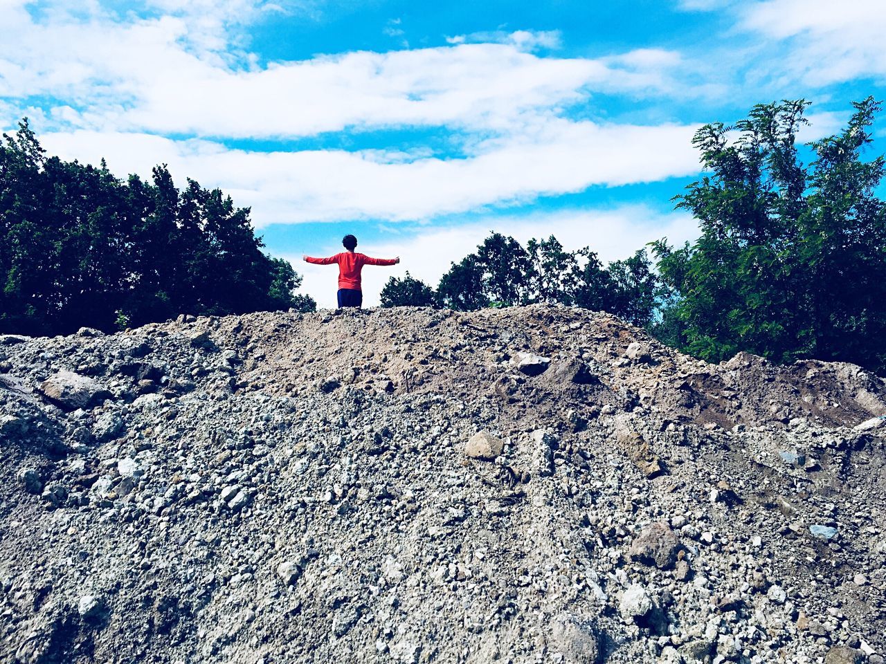 real people, sky, one person, cloud - sky, lifestyles, tree, nature, day, rear view, plant, rock, solid, leisure activity, rock - object, standing, beauty in nature, land, scenics - nature, outdoors