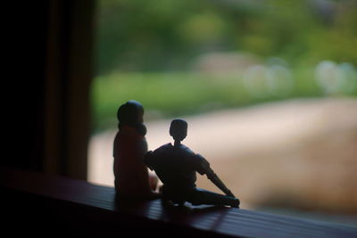 Close-up of figurines on window sill