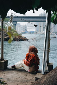 Side view of a man sitting on shore