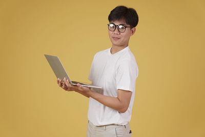 Portrait of smiling young man using smart phone