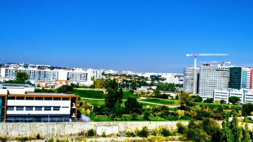 Buildings in city against blue sky