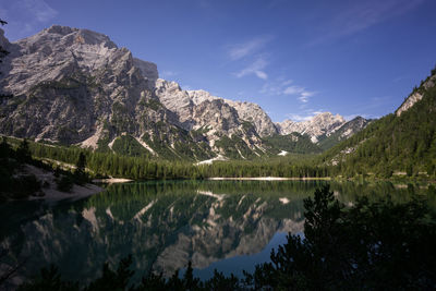 Scenic view of lake and mountains against blue sky