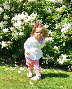 Happy girl standing against pink flowers