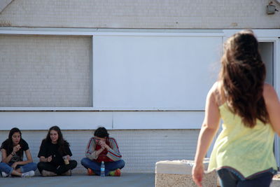 Women sitting on wall