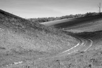 Road amidst field against sky