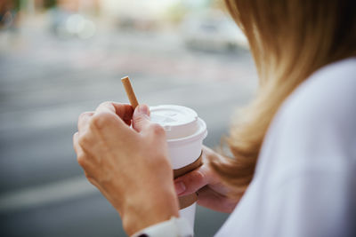 Midsection of woman holding coffee cup