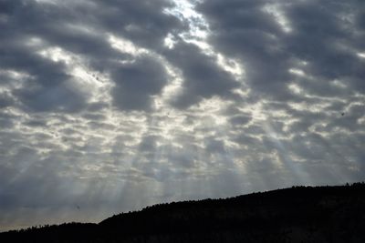 Low angle view of silhouette landscape against dramatic sky