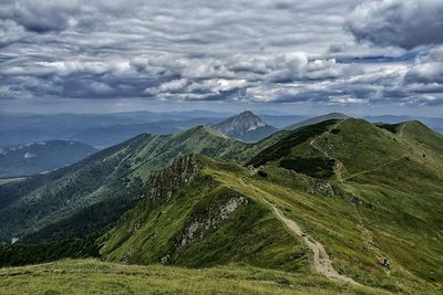 Scenic view of mountains against cloudy sky