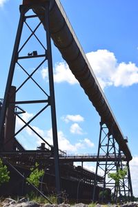 Low angle view of bridge against cloudy sky