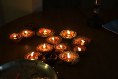 Lit diyas on table during diwali