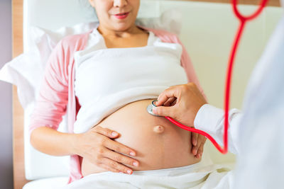 Midsection of woman with arms raised