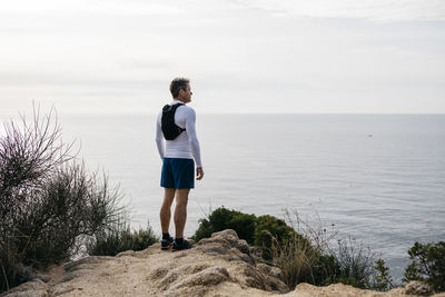 Rear view of man standing on beach