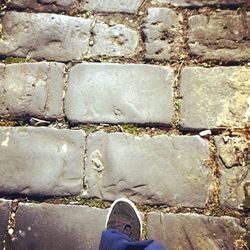 Low section of person standing on tiled floor