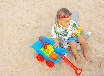 High angle view of boy playing with toy on beach