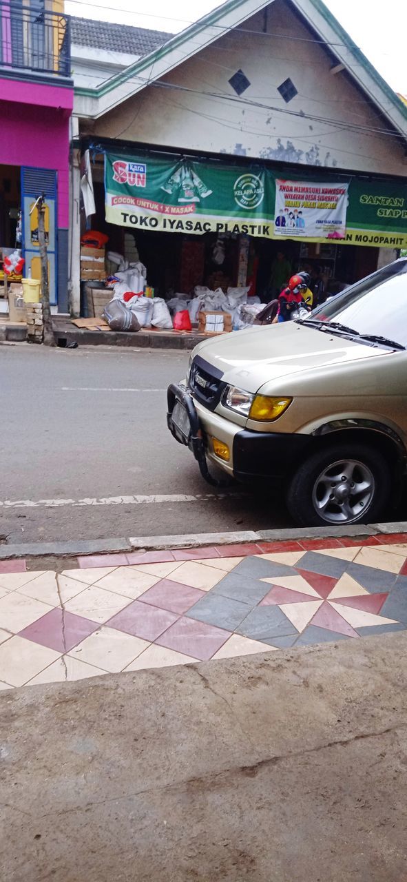 CARS ON ROAD BY BUILDING