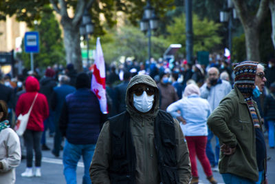 Rear view of people walking on street in city